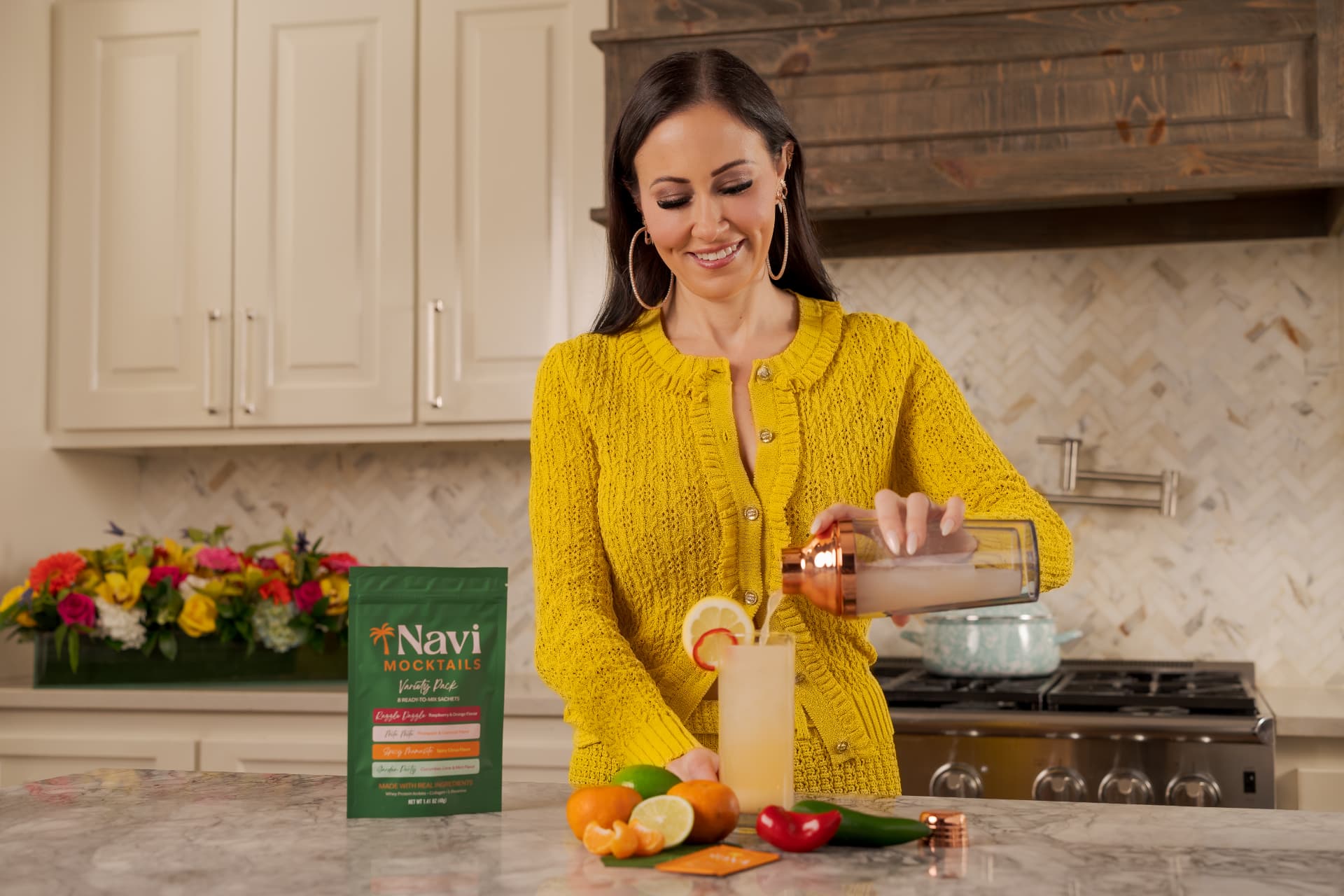 Emily pouring a Navi mocktail into a tall glass over ice